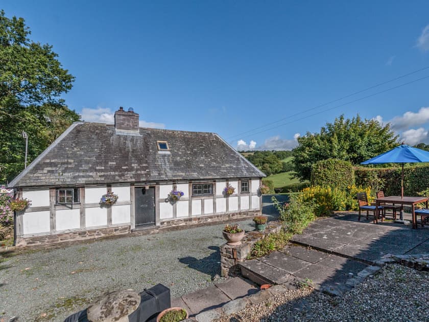 Exterior of the A Grade II listed 17th century timber and stone holiday cottage | Pen Copi, Trefeglwys, near Caersws